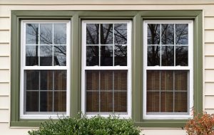 three windows framed in color green from outside home with white siding in Pittsburgh, PA