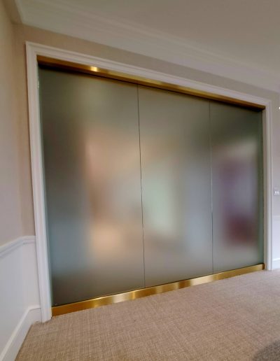 Wall with long rectangular windows with frosted glass by beige carpet