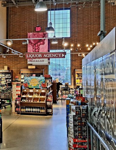Interior of grocery store with brick walls, rectangular windows and exposed ductwork