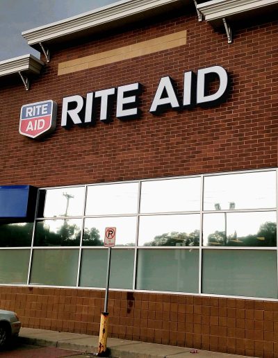 Rite Aid Retail store with brick exterior and long rectangular mirrored windows divided by silver metal