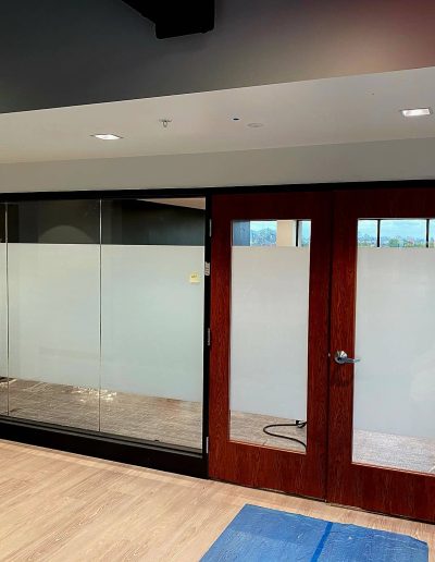Interior office with frosted glass windows ,wooden door with frosted glass inlay and light wood floor