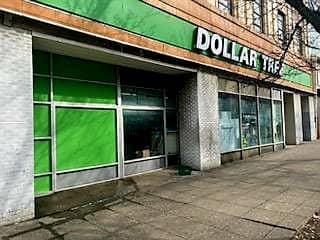 Curbside view of Dollar Tree retail location with large windows, green frosted glass and green Dollar Tree sign on front