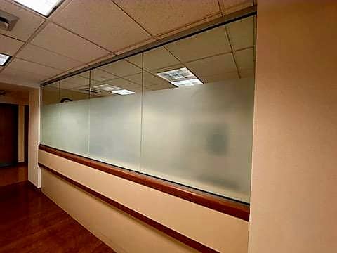 Office hallway with wooden floors and large frosted windows for wall with wood trim